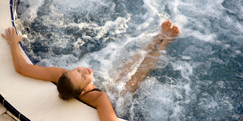 Woman relaxing in a hot tub alone