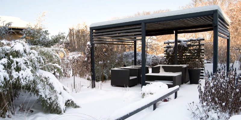 Patio furniture in winter covered in snow