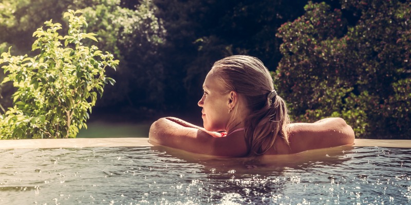 Women in hot tub looking out into yard - Are there any safety precautions to keep in mind when using a hot tub?